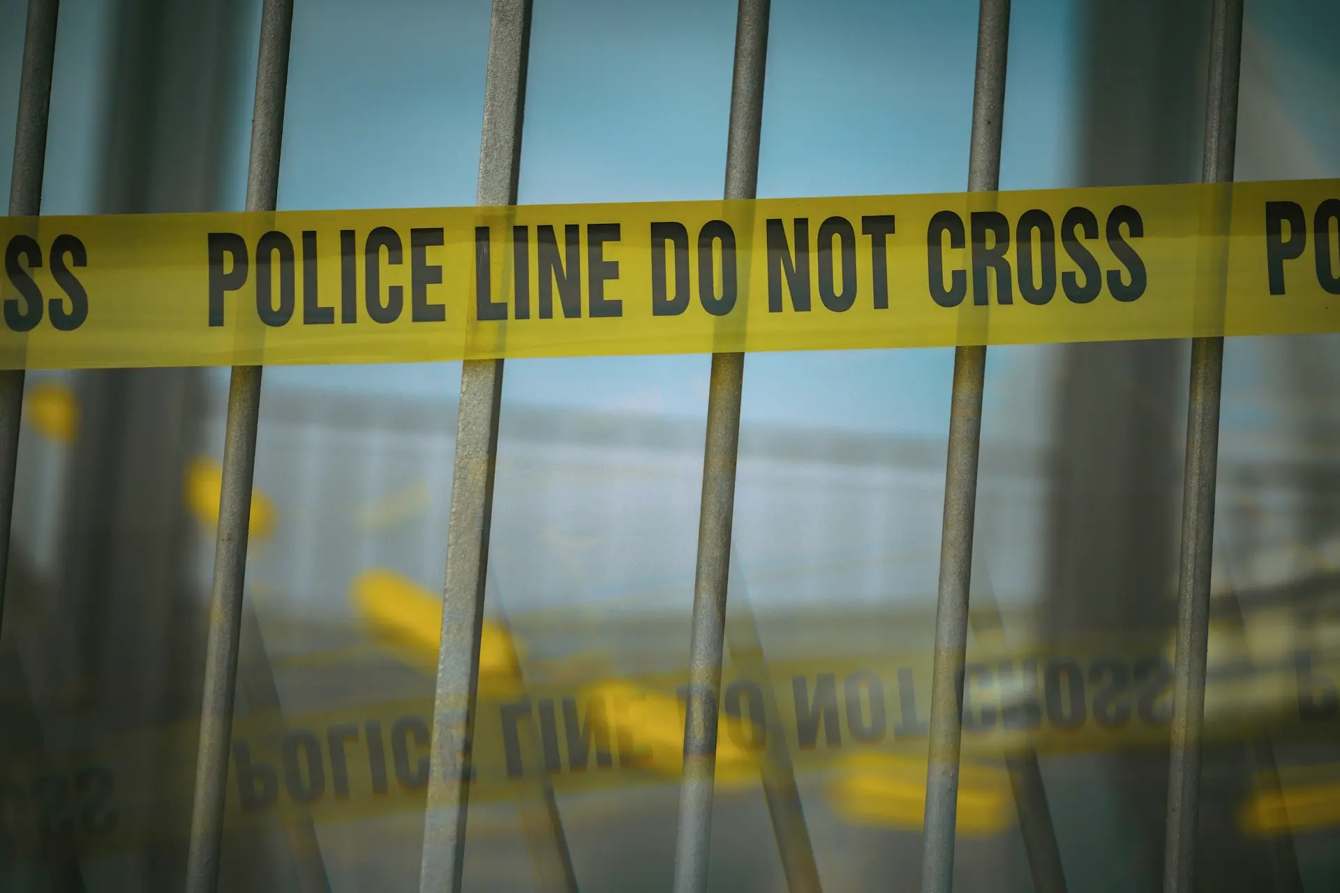 a close up of a yellow police line behind bars